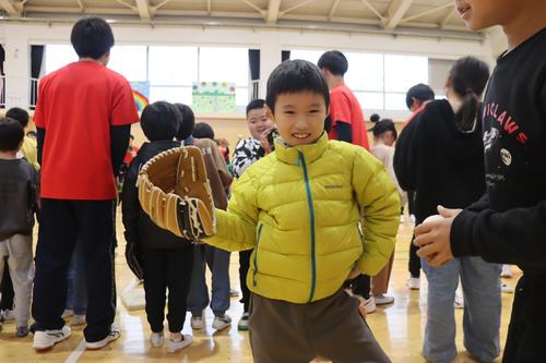 大谷翔平選手から送られた３個のグラブはサイズと利き手が異なる３種類。左利きの小学生も笑顔でポーズ